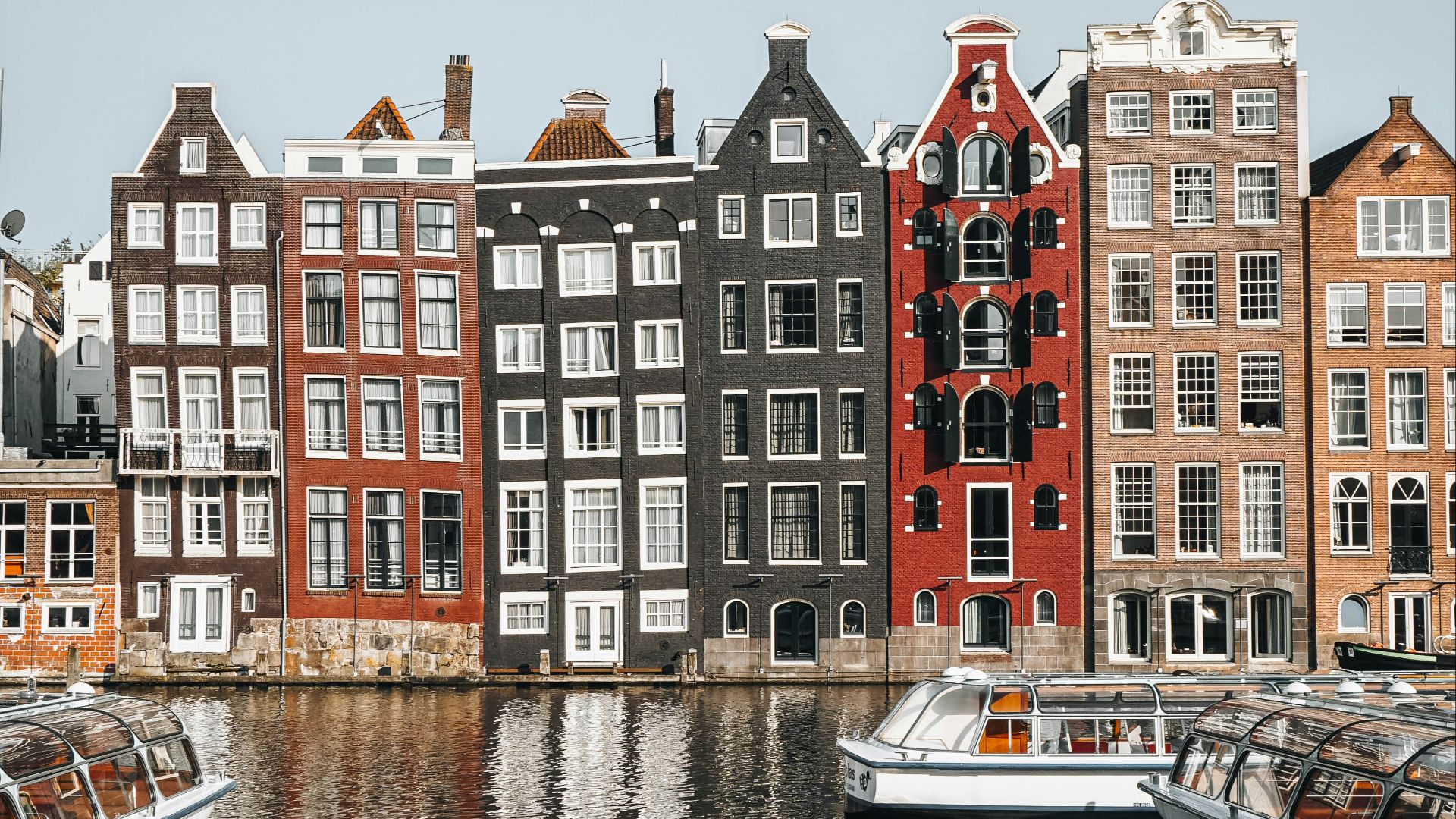 white and brown boat on water near brown concrete building during daytime