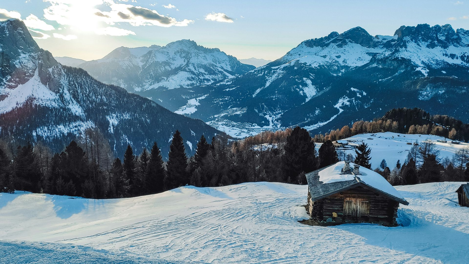 a cabin in the middle of a snowy mountain range
