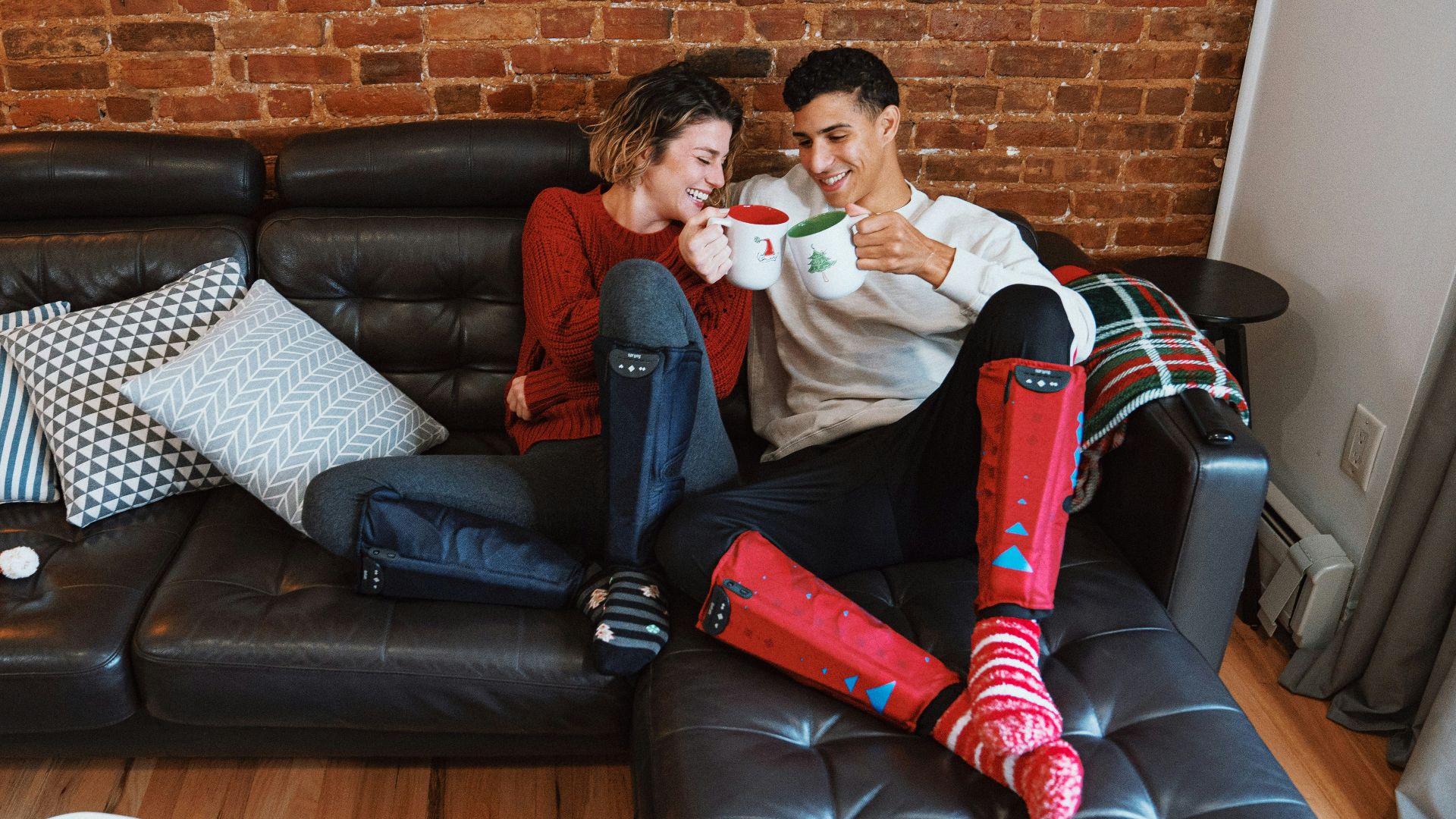 a man and a woman sitting on a couch with a santa clause garment