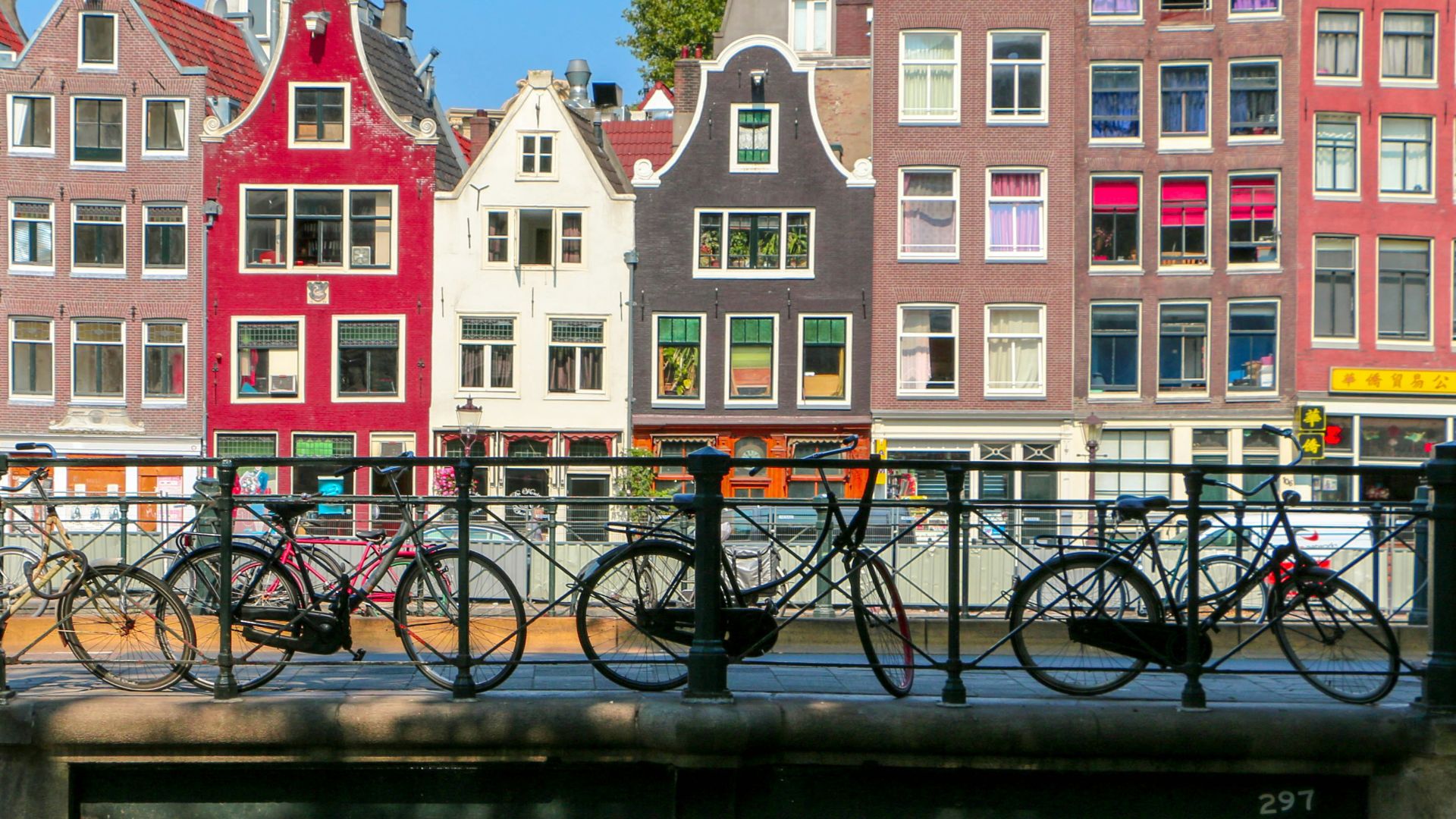 black bicycle leaning on black metal fence