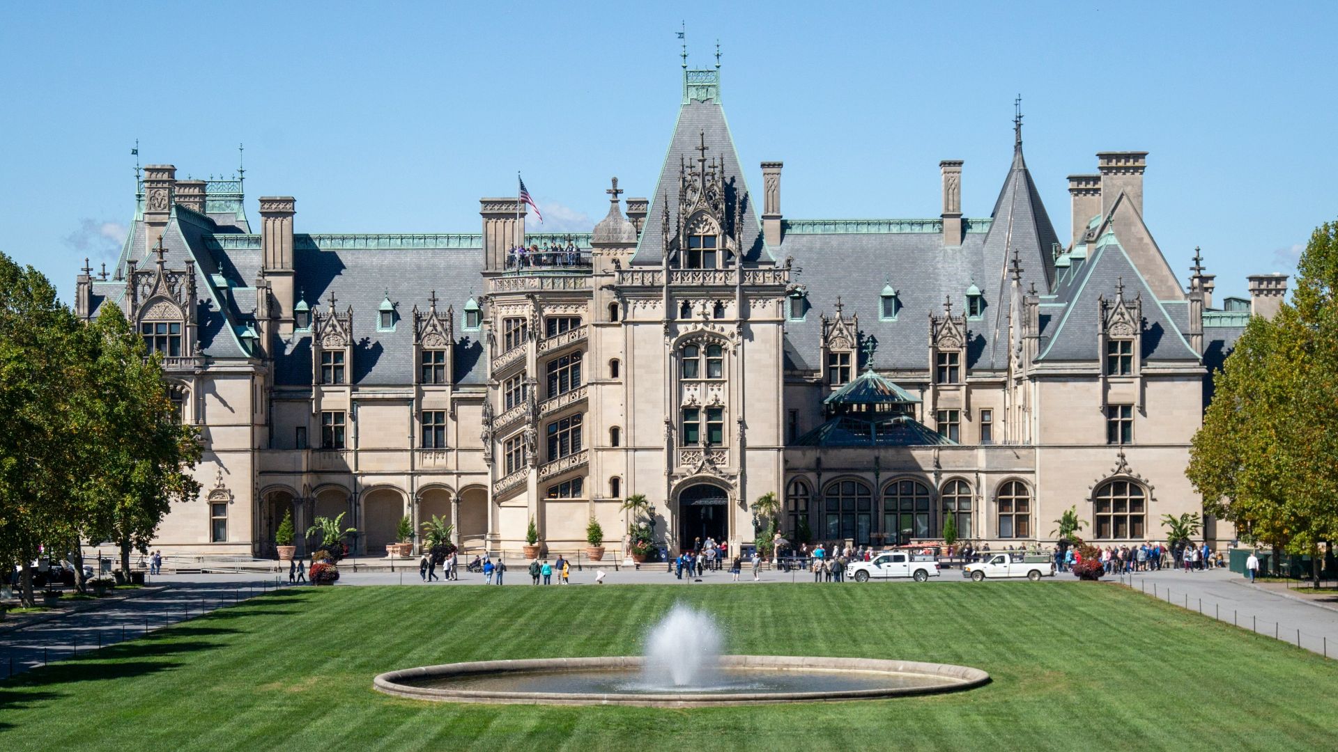 a large building with a fountain in front of it with Biltmore Estate in the background