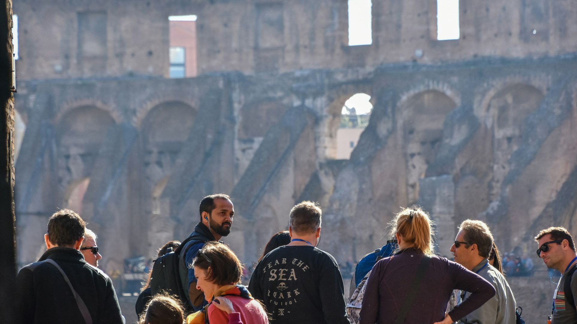 Tourists looking at the ancient roman colosseum ruins