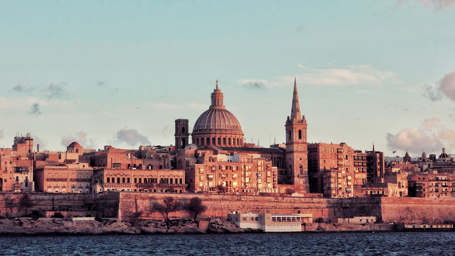 brown concrete dome building near body of water