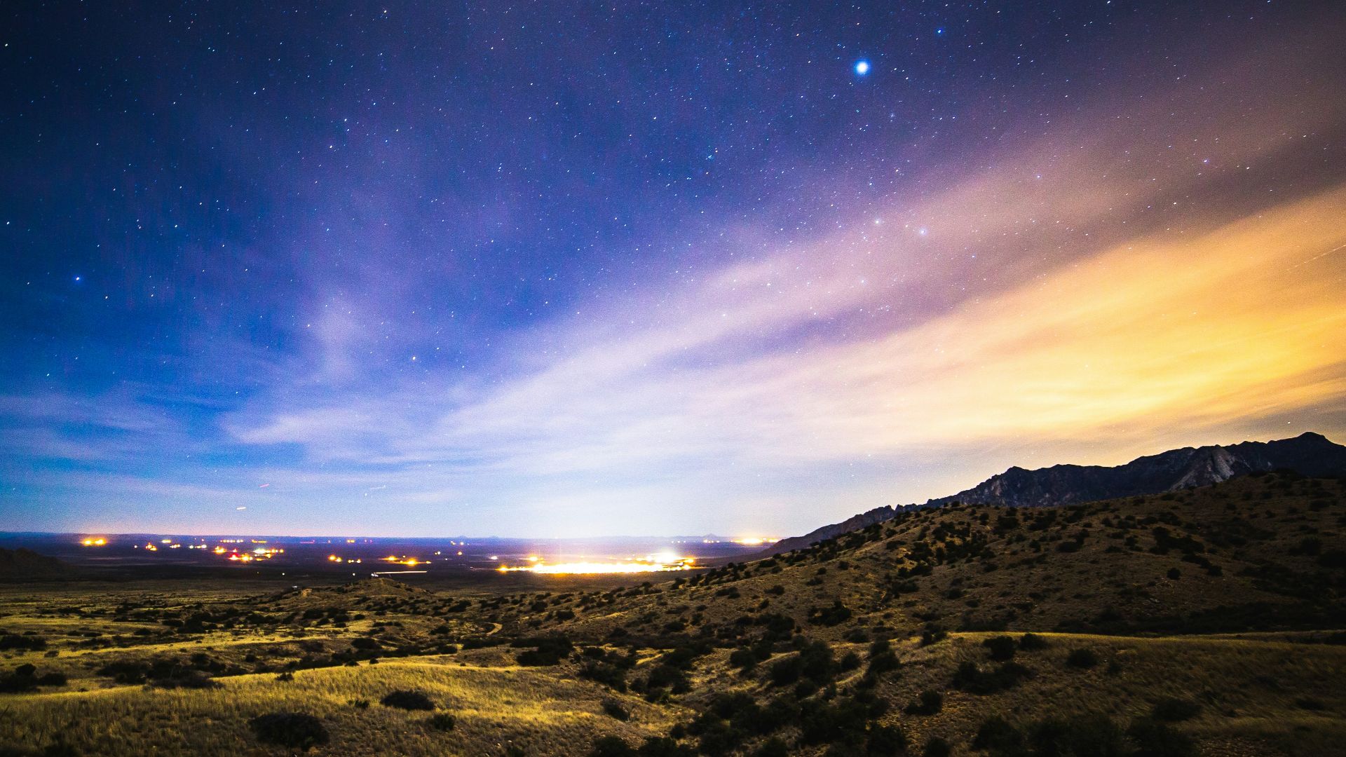 brown and green mountains under blue sky during night time