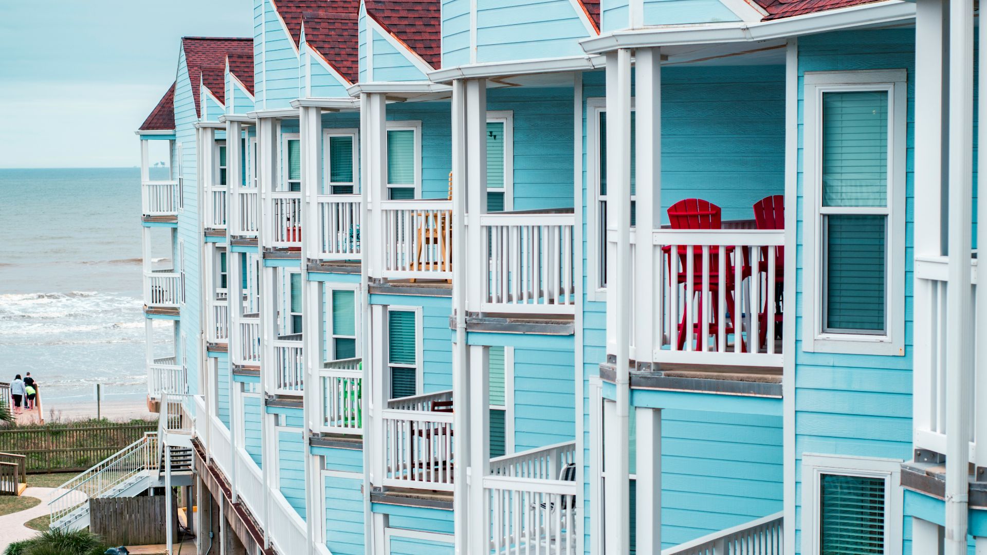 white and red concrete house near body of water during daytime
