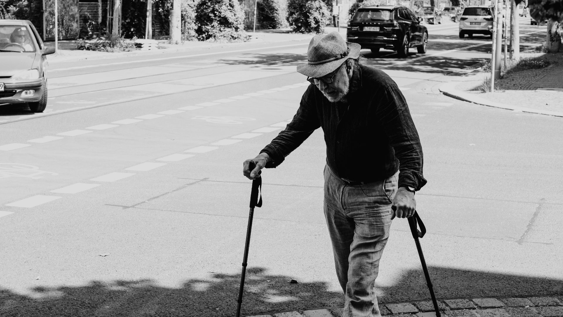 man in black jacket and white pants holding black skateboard