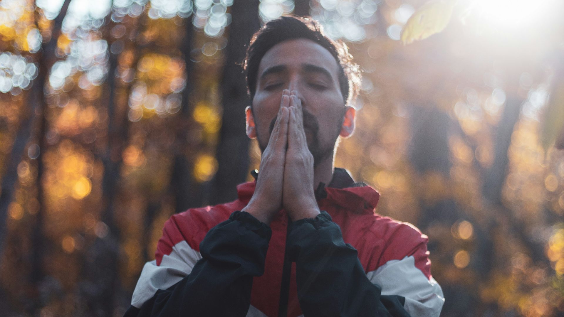 shallow focus photo of man in black, white, and red full-zip hoodie