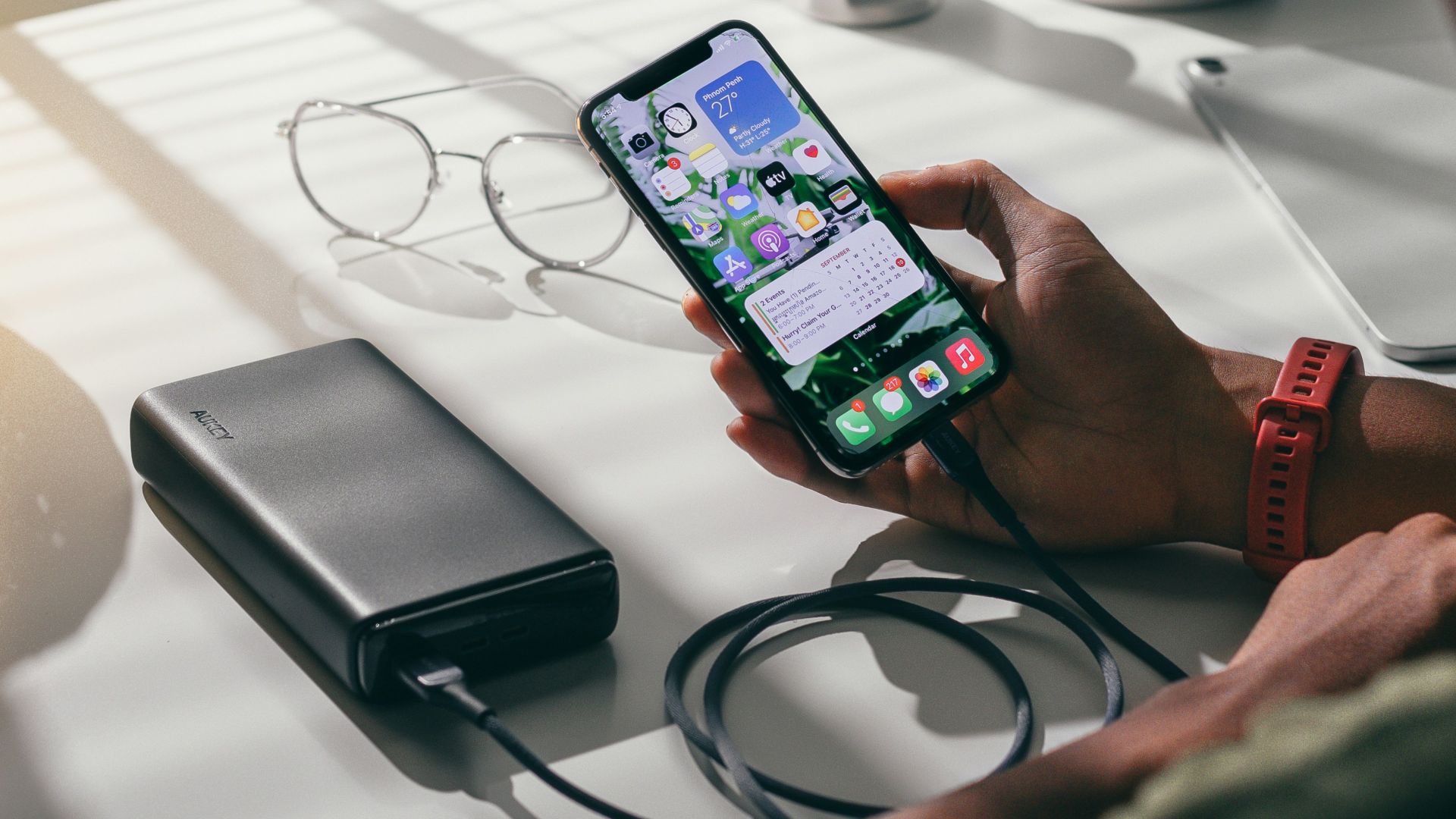 person holding black smartphone on white textile