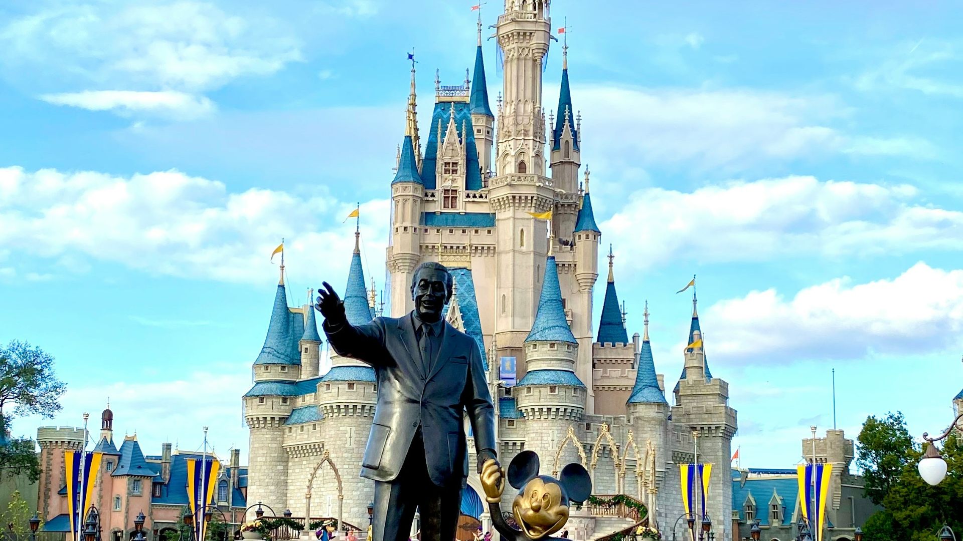 people walking on park near disney castle during daytime