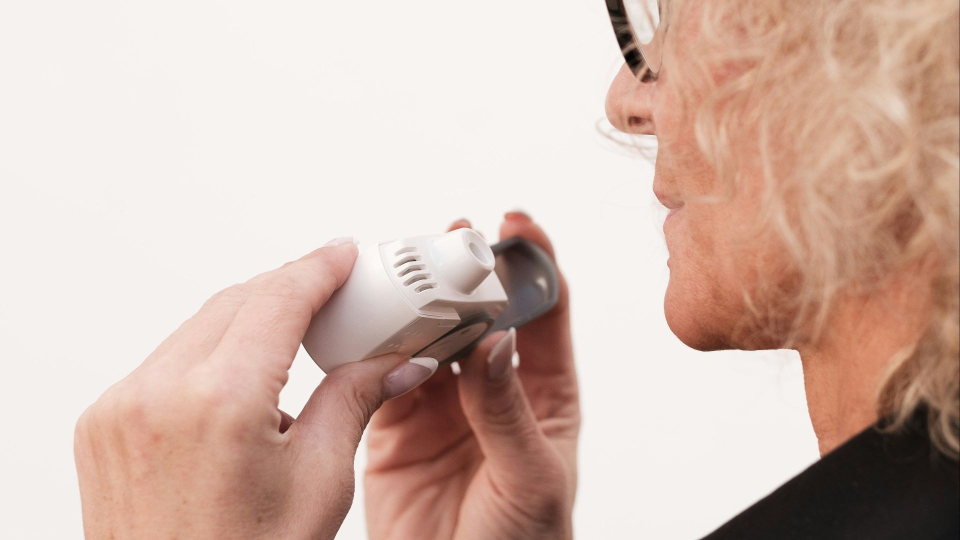 A woman holding a video game controller in her right hand
