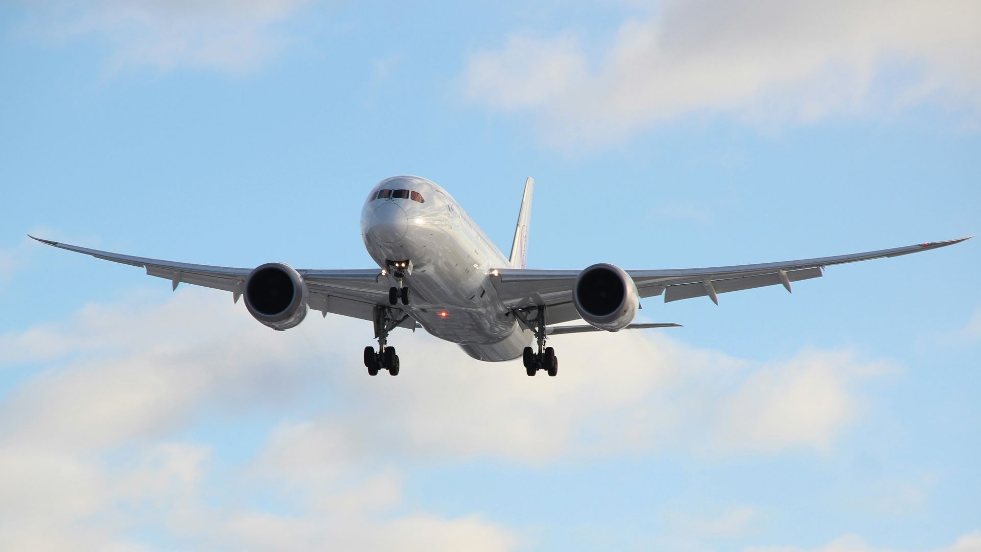 white passenger plane in mid air during daytime