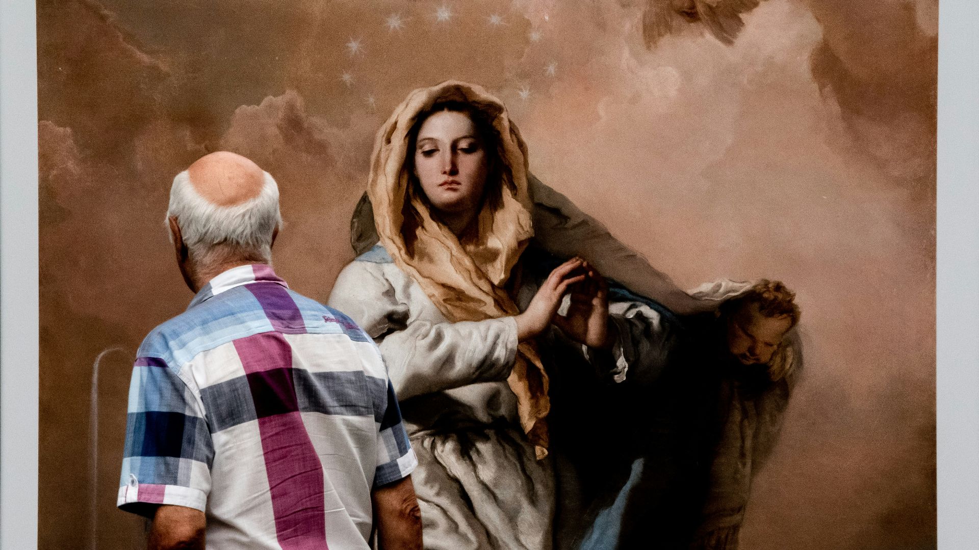 a man standing next to a painting of a woman