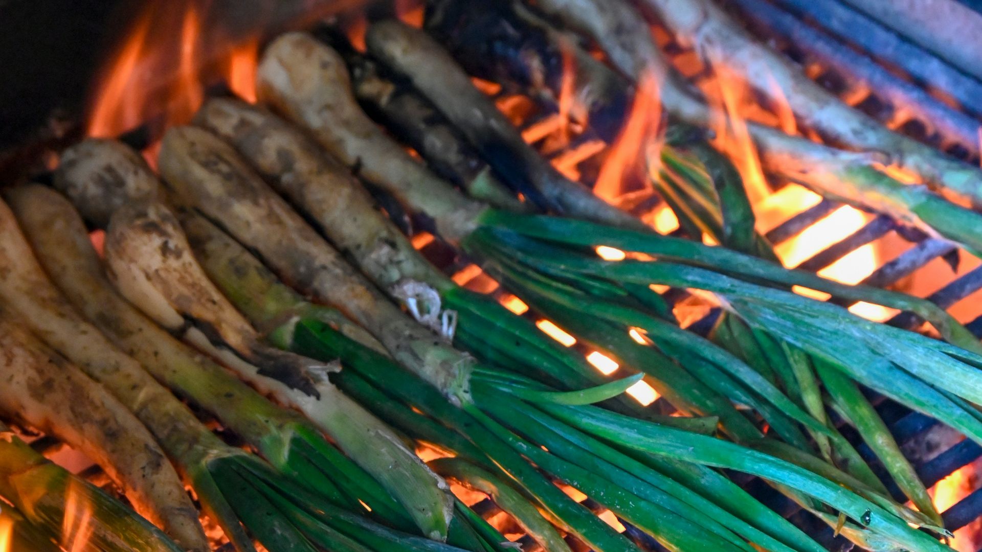 a bunch of sticks are cooking on a grill