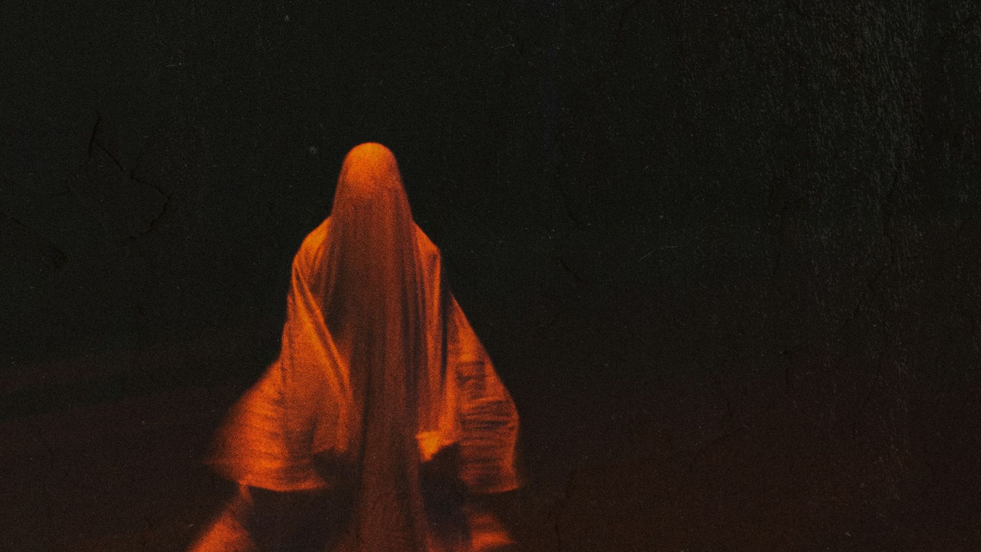 woman in orange hijab standing on black surface