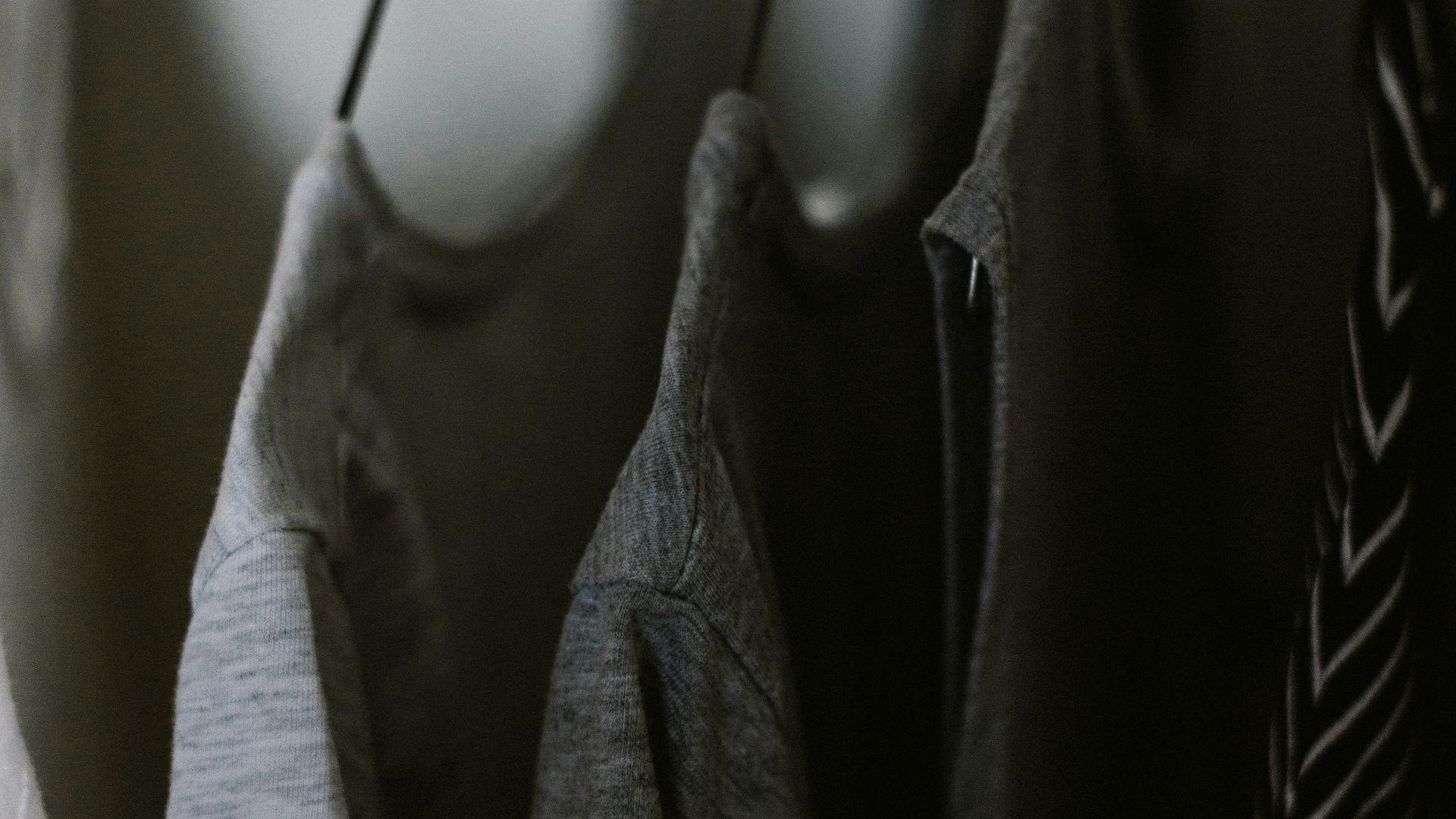 selective focus photography of hanged three gray tee shirts