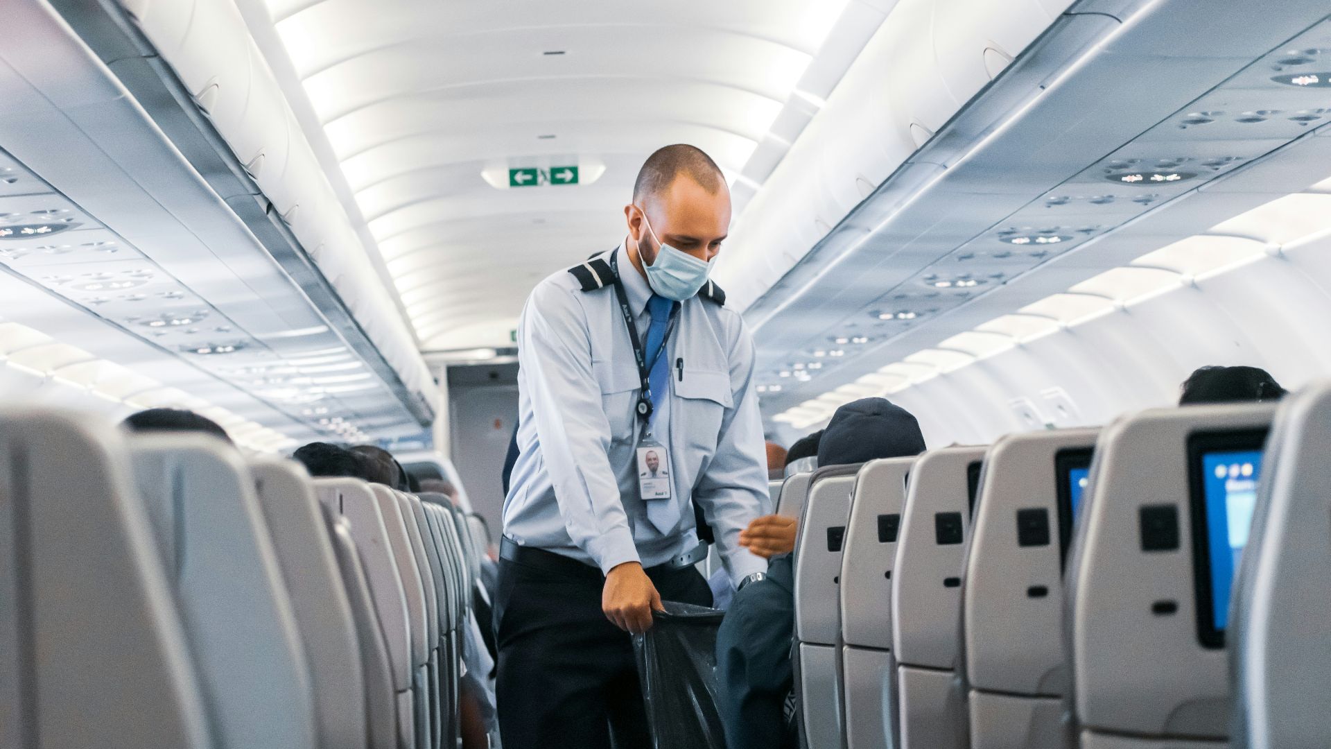 man in blue dress shirt standing in airplane