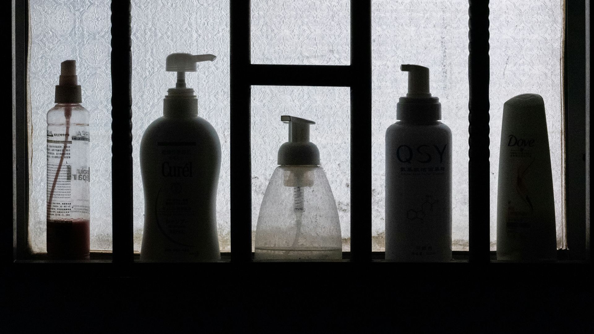 3 bottles on black wooden shelf