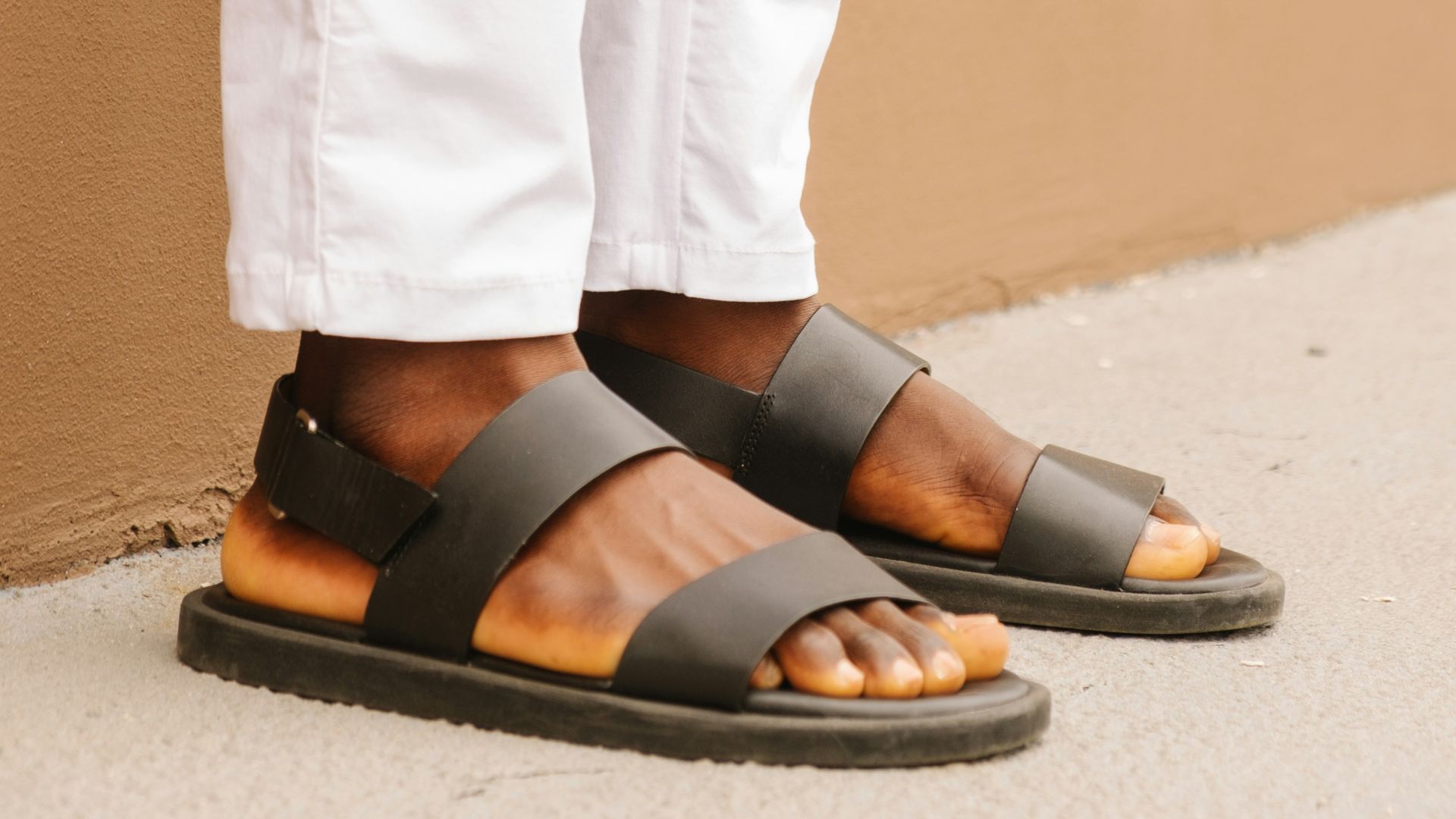 person wearing black leather sandals