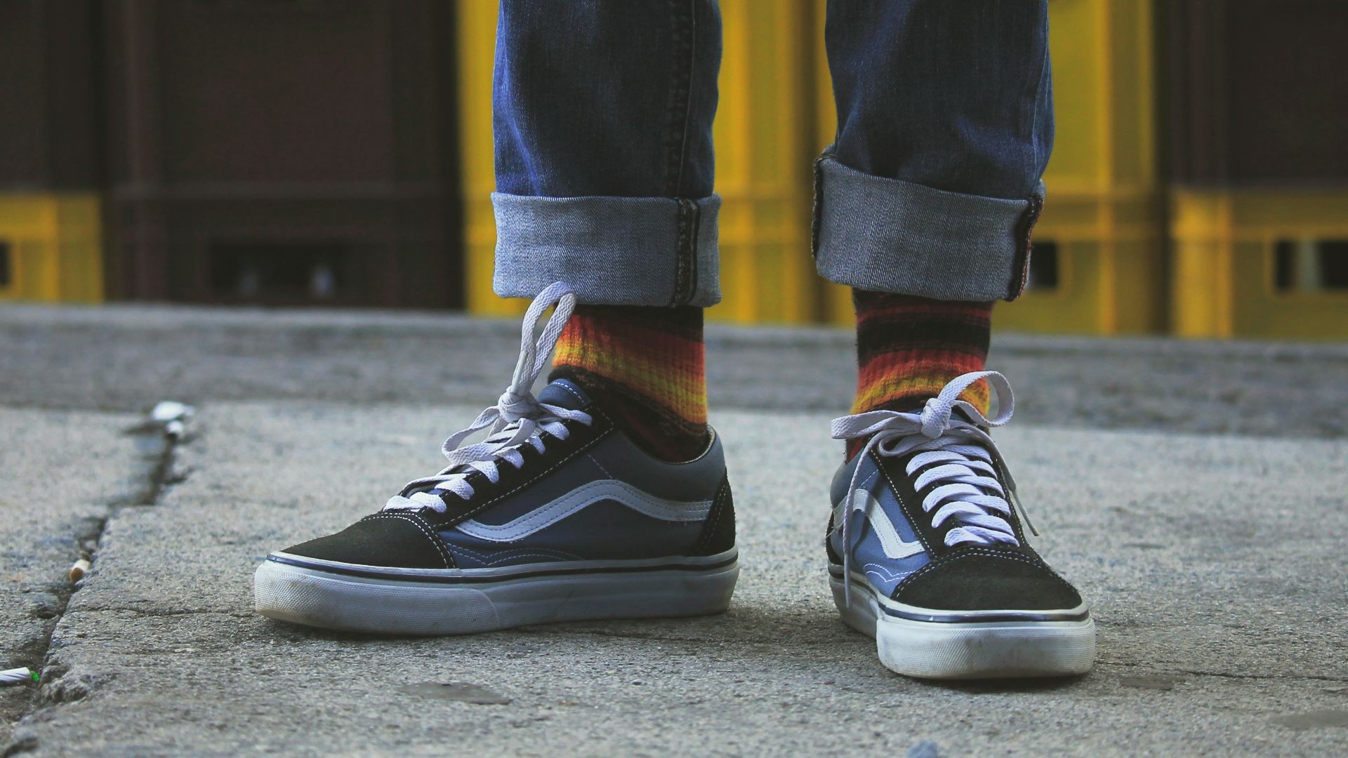 person wearing black Vans Old Skool shoes