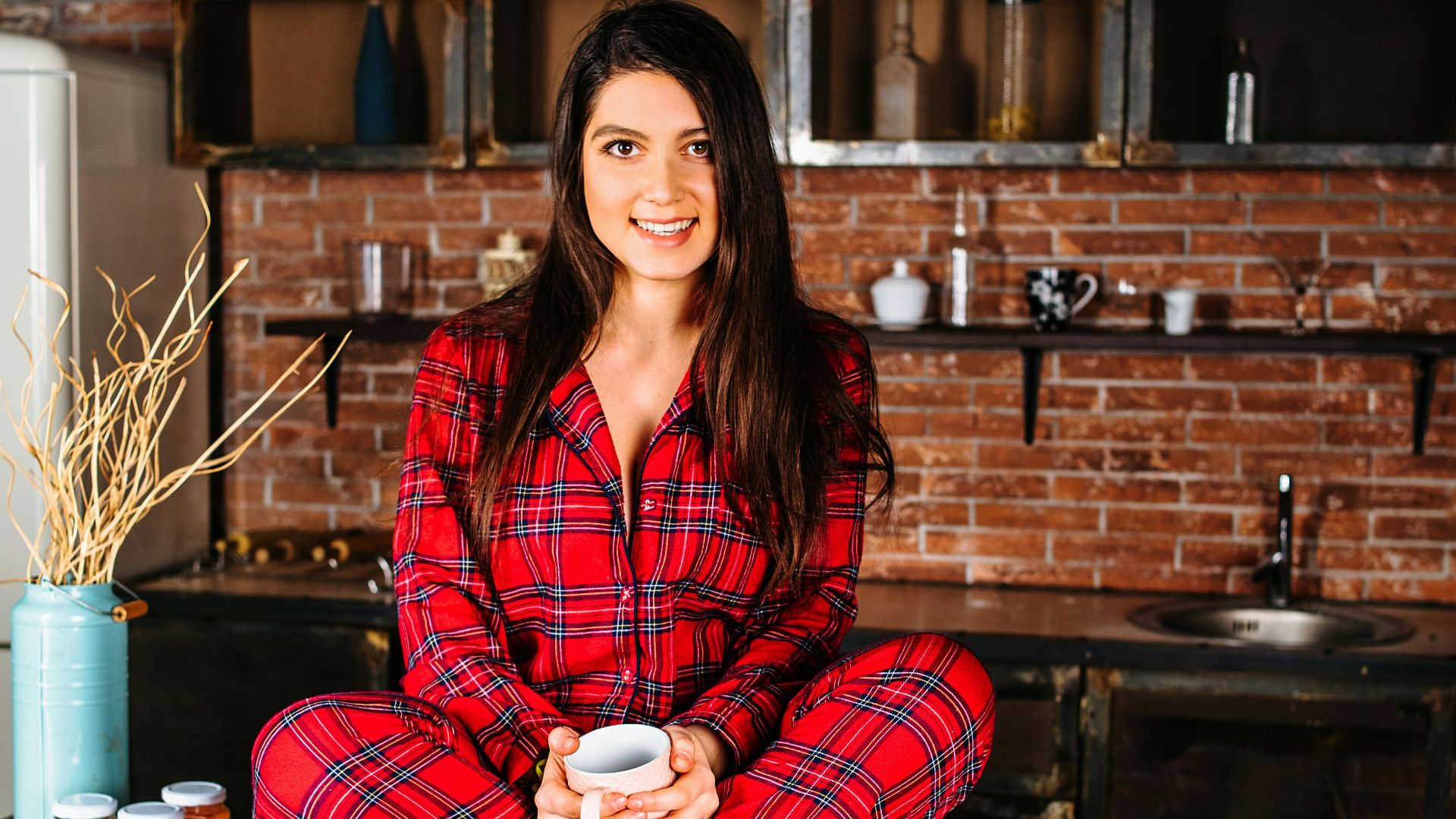woman in red and white plaid coat sitting on brown wooden table