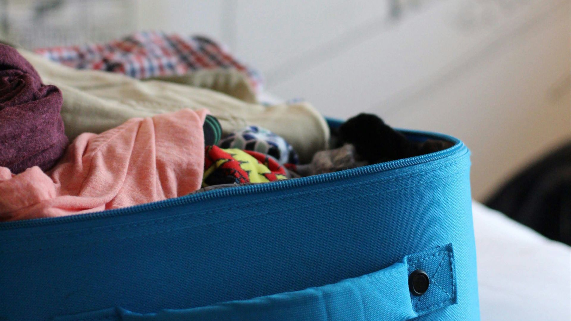 selective focus photo of luggage bag filled with clothes