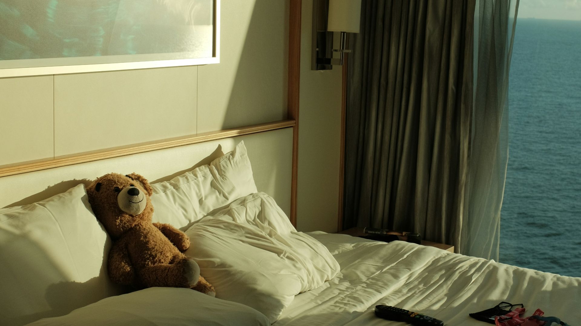 a teddy bear lays on a bed