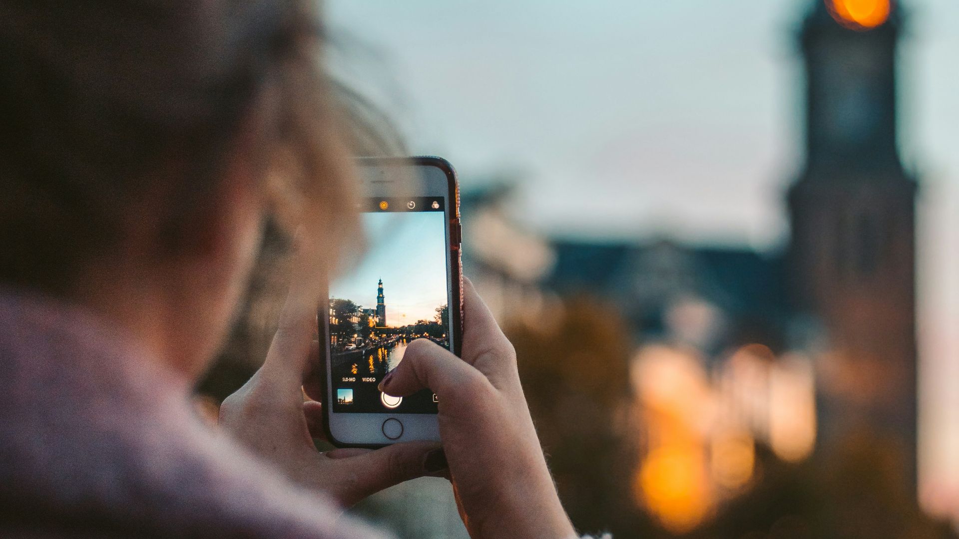 woman taking photo of a building during daytime