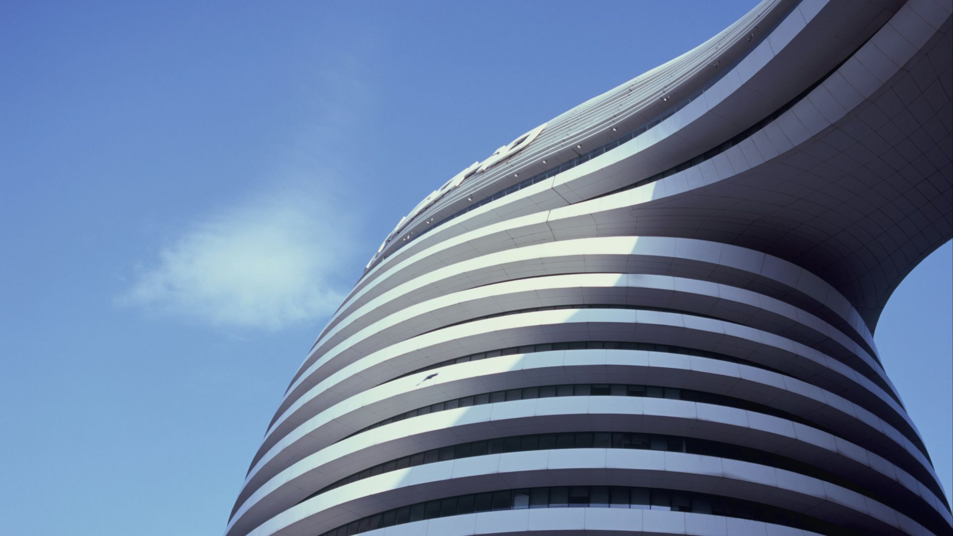 a curved building with a sky background