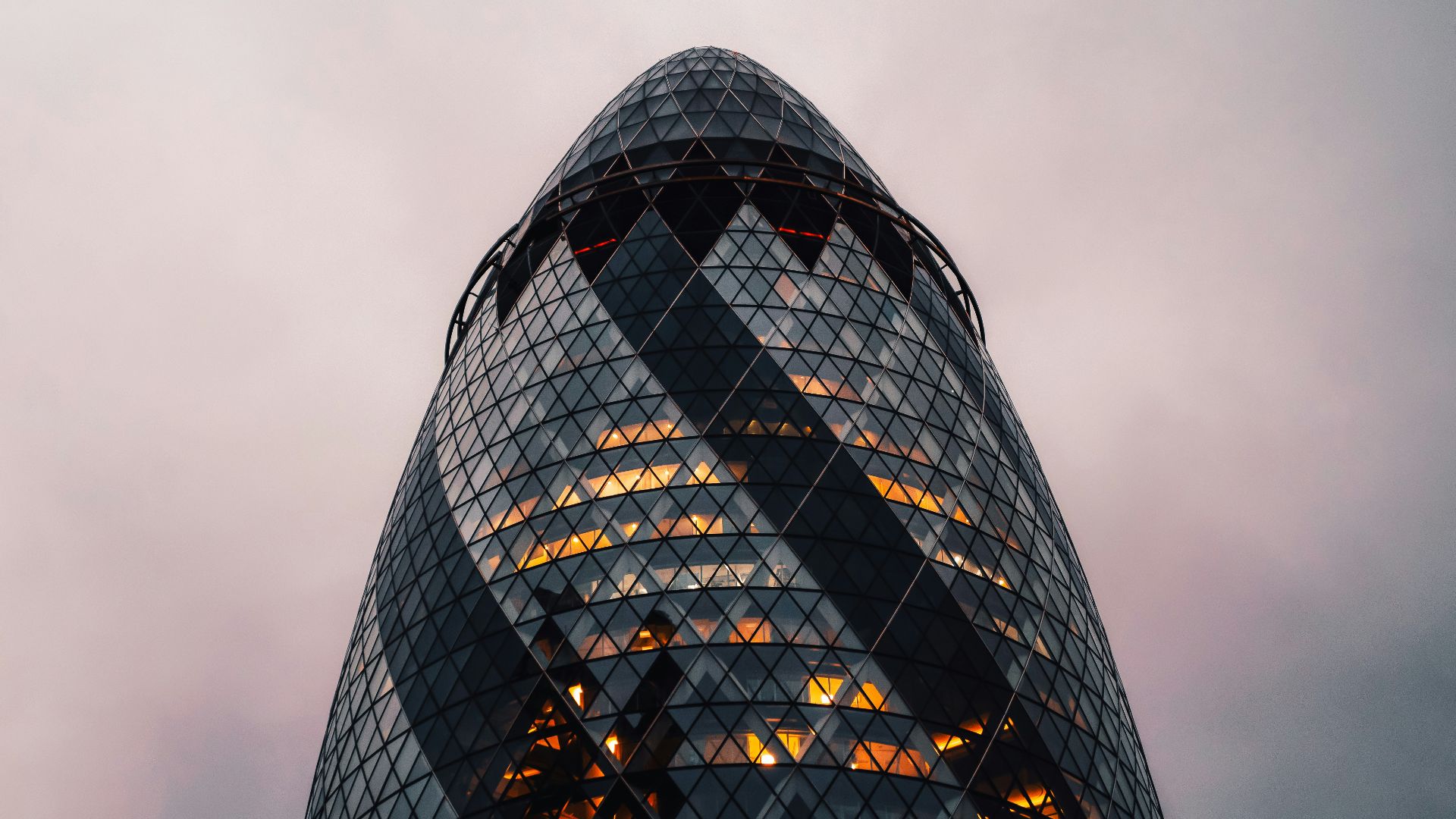 a very tall glass building with a sky background