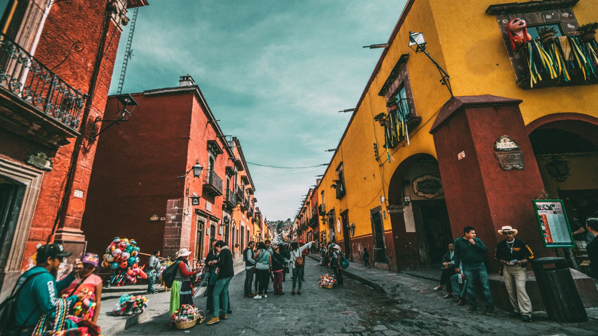 people standing on corner road near concrete buildings during daytime