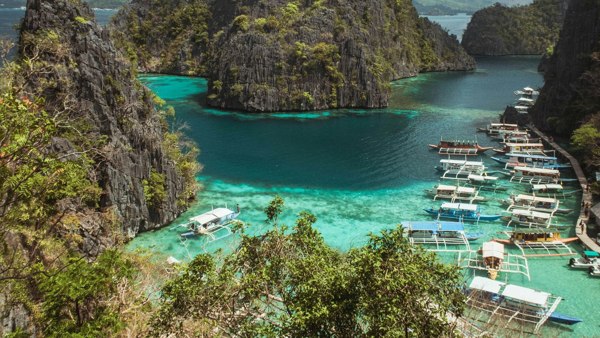 green and brown mountain beside body of water under blue sky during daytime