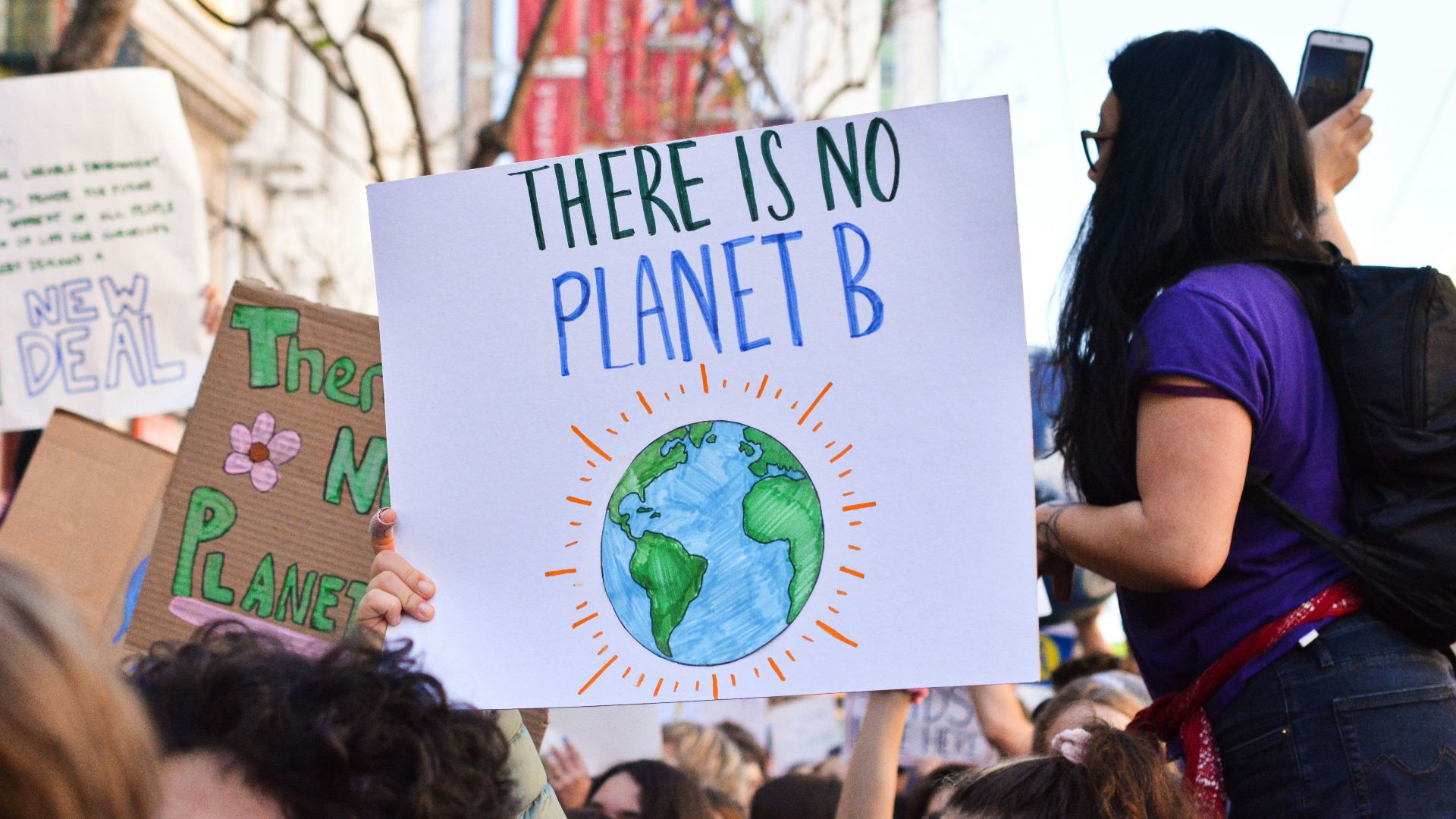 person holding there is no planet b poster