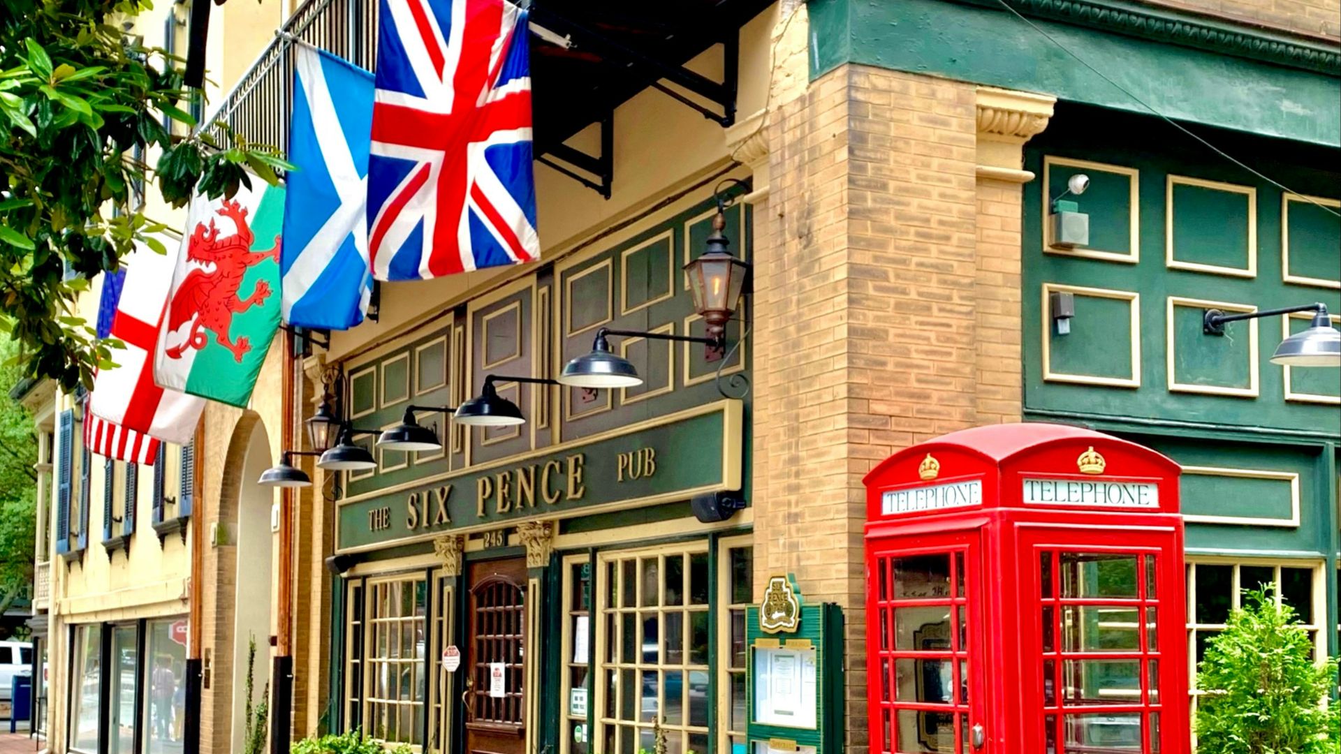 red telephone booth in front of brown building