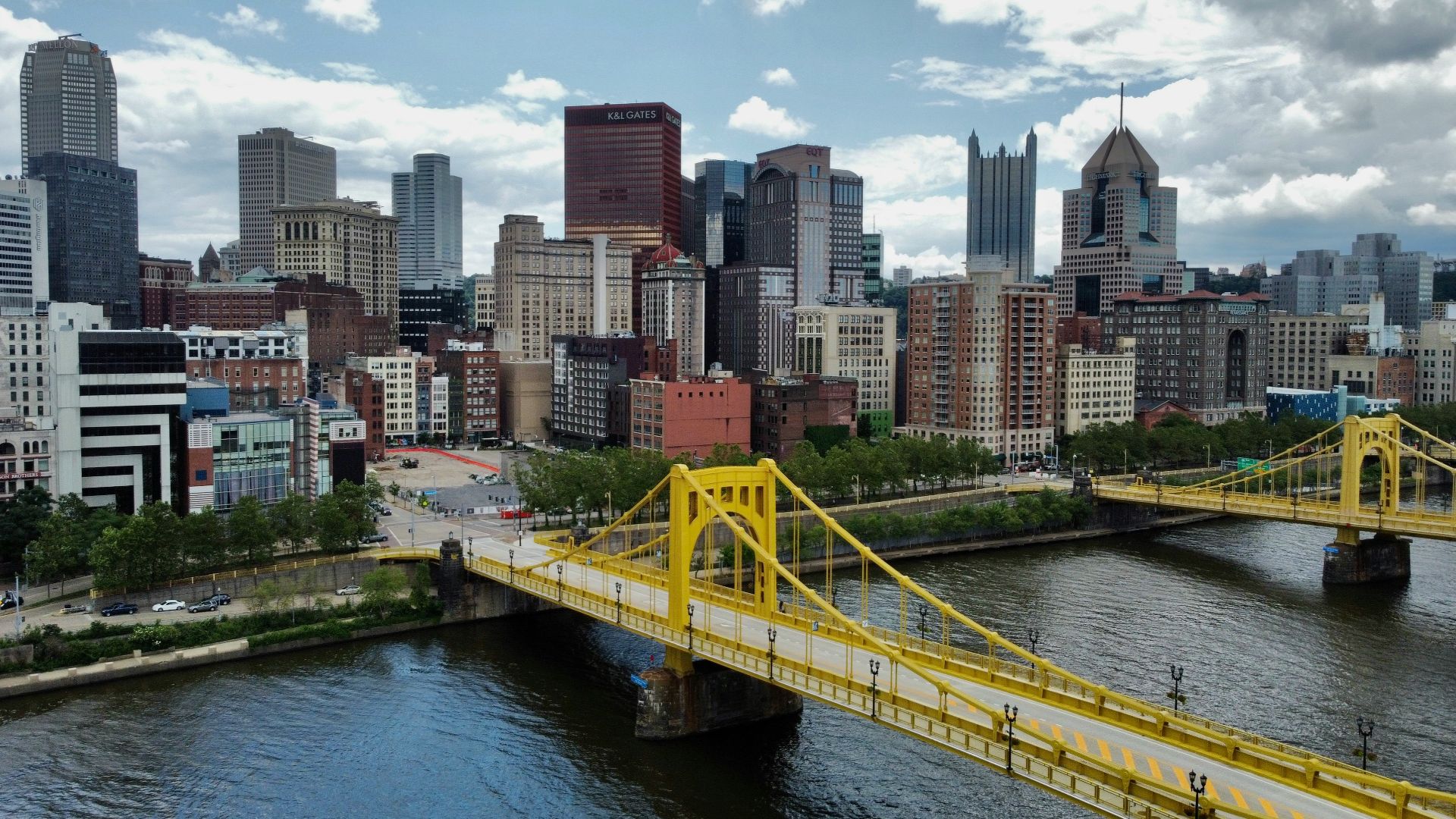 yellow bridge over river near city buildings during daytime