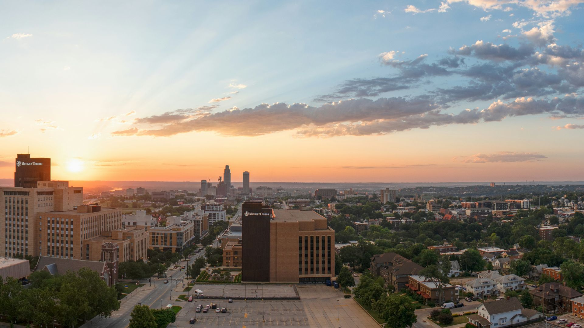 The sun is setting over a city with tall buildings