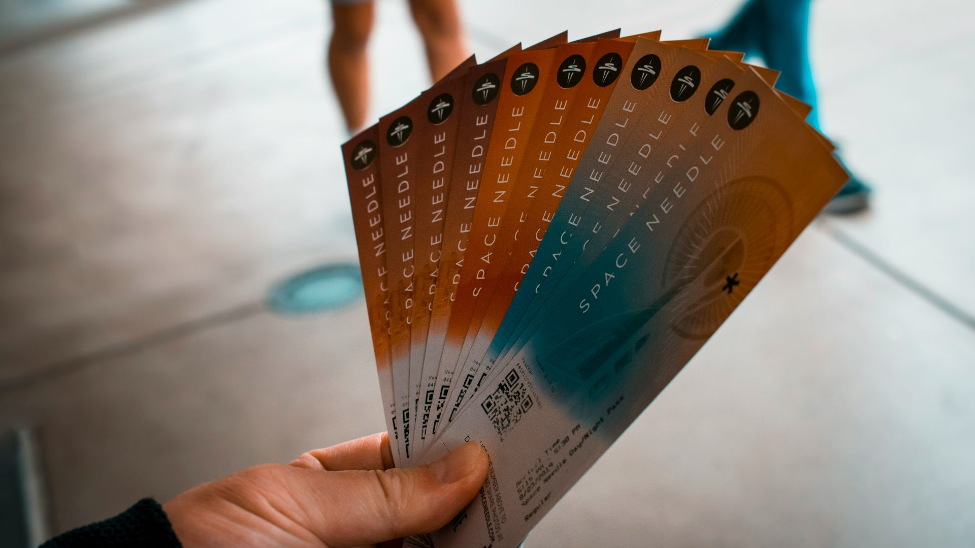 person holding brown, blue, and white tickets