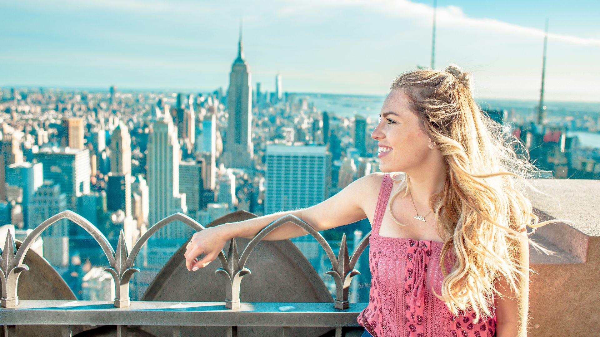 woman on top of tower and overlooking Empire State Building