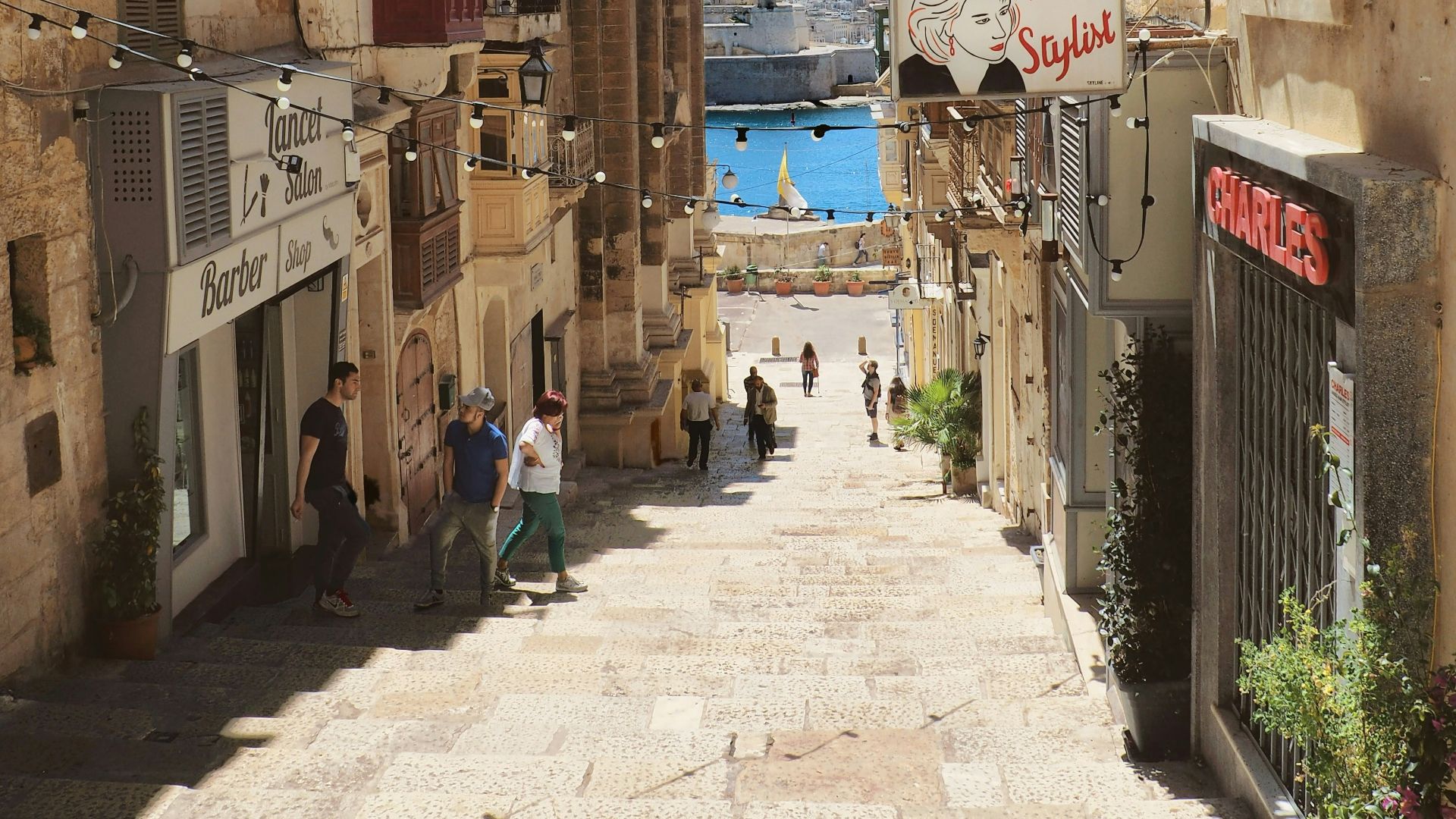 people walking on stairs between buildings in distant of mountain