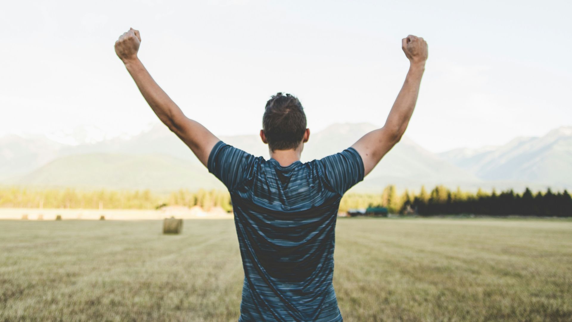 man reaching hands up high taken at daytime