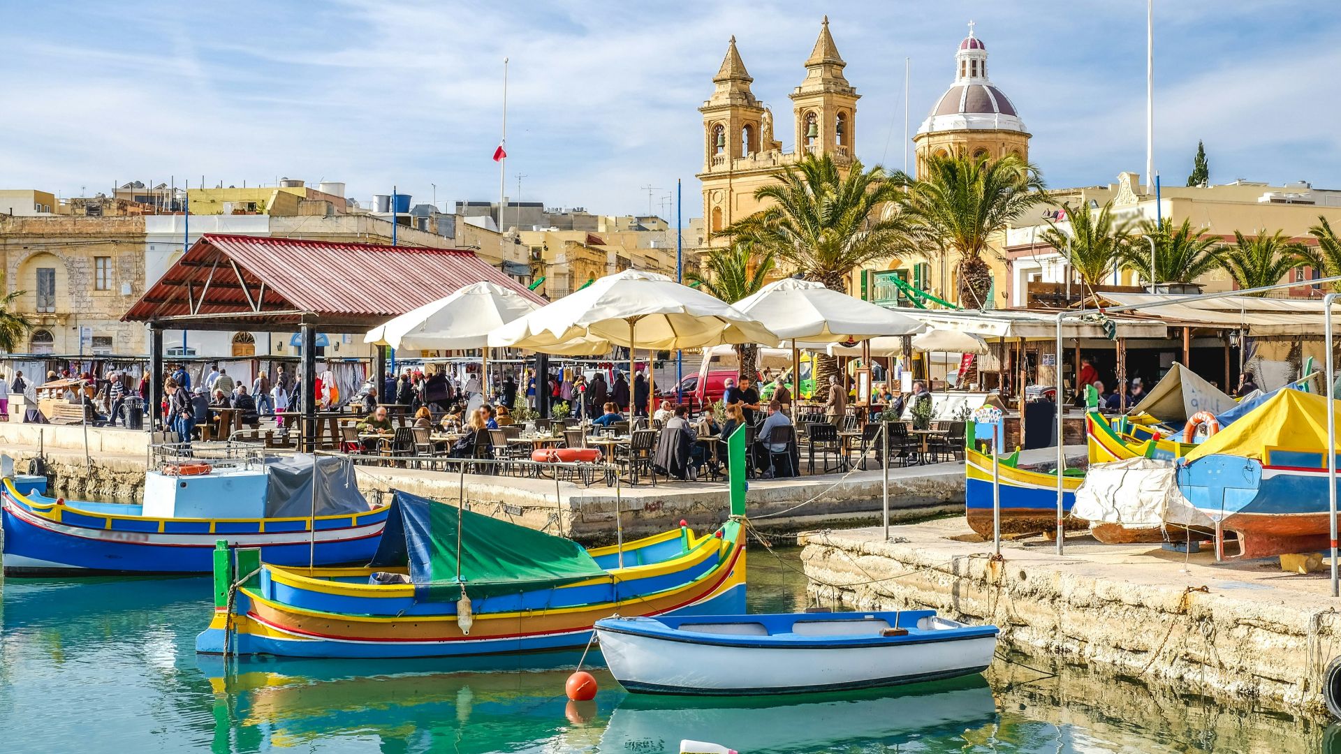blue and yellow boat on water near brown concrete building during daytime