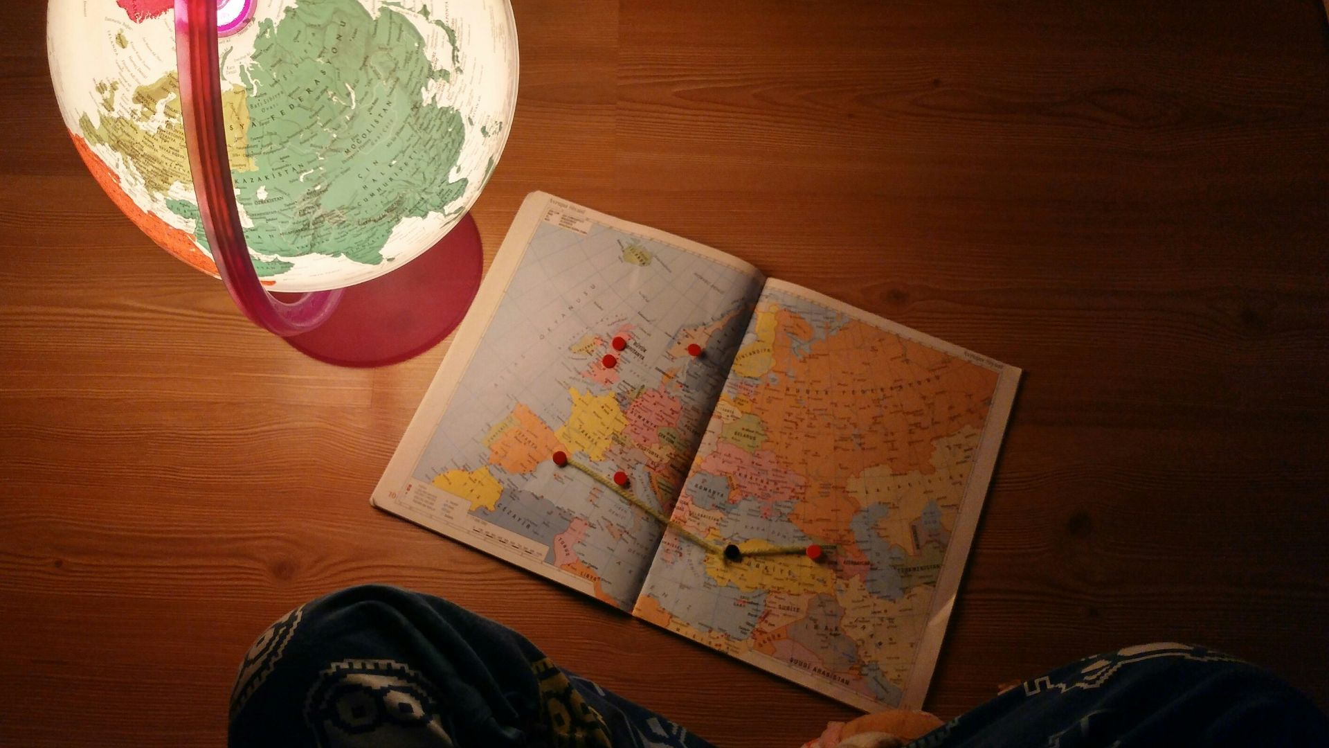 world map near desk globe on brown wooden panel