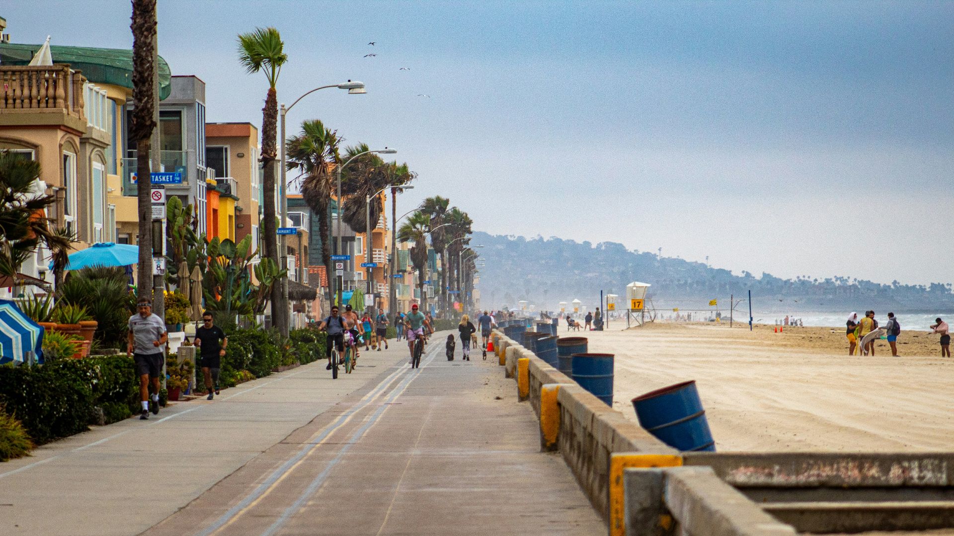 people walking on sidewalk near body of water during daytime