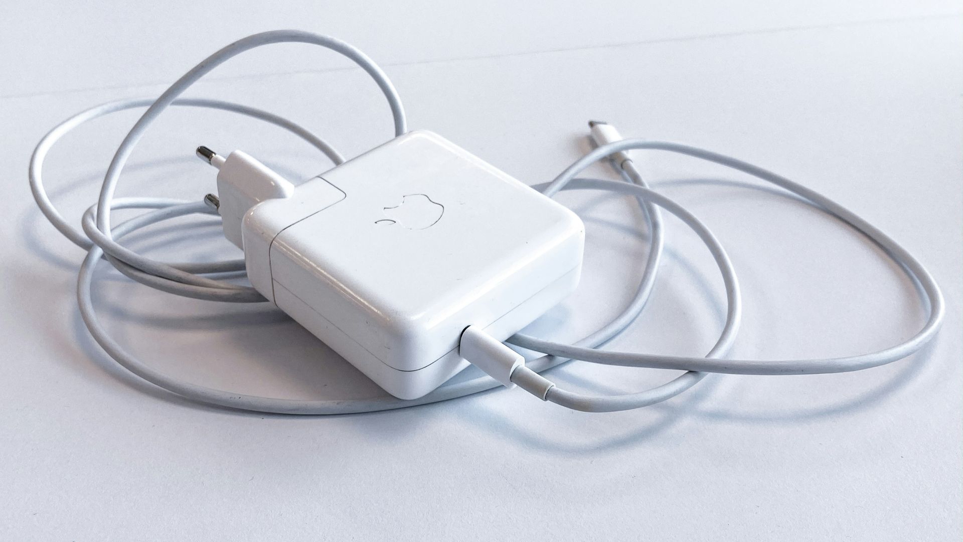white apple charging adapter on white table