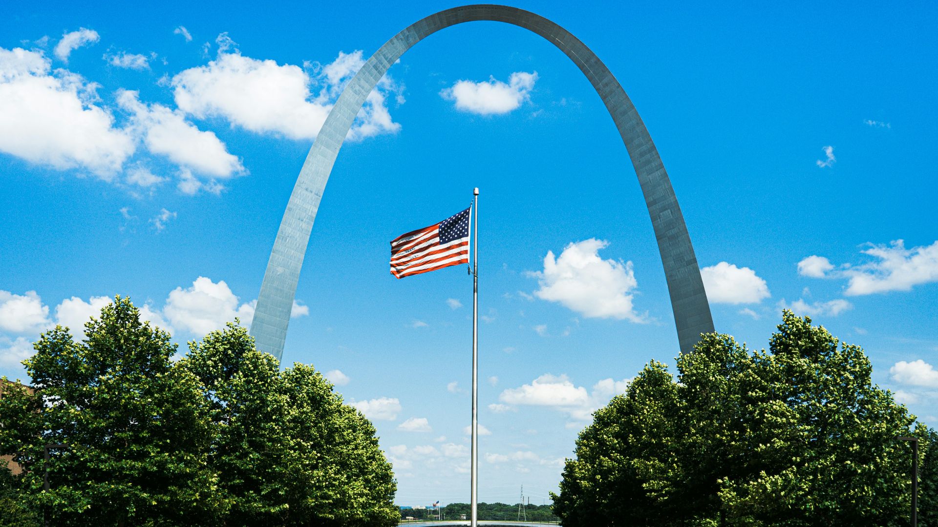 us flag on pole near trees during daytime