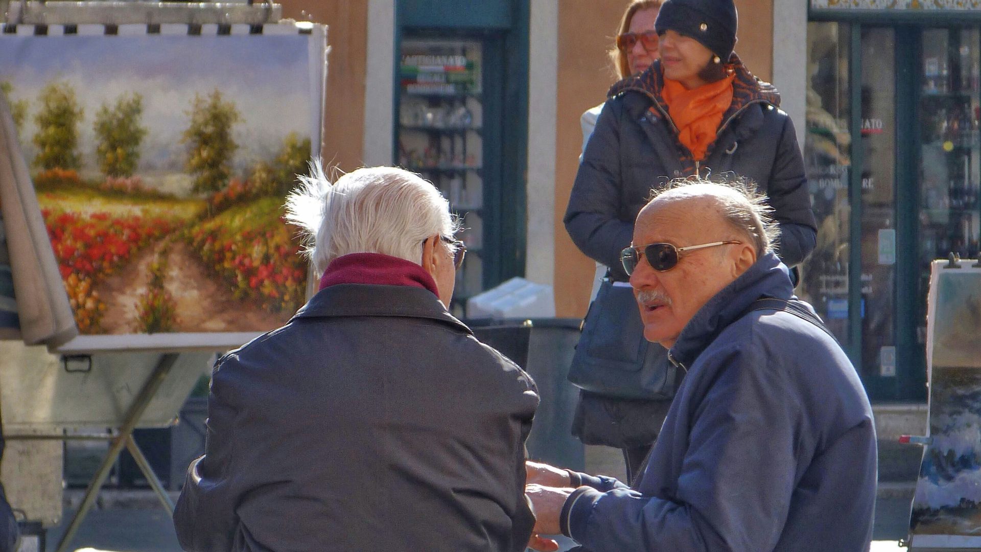 shallow focus photo of person sitting on concrete bench