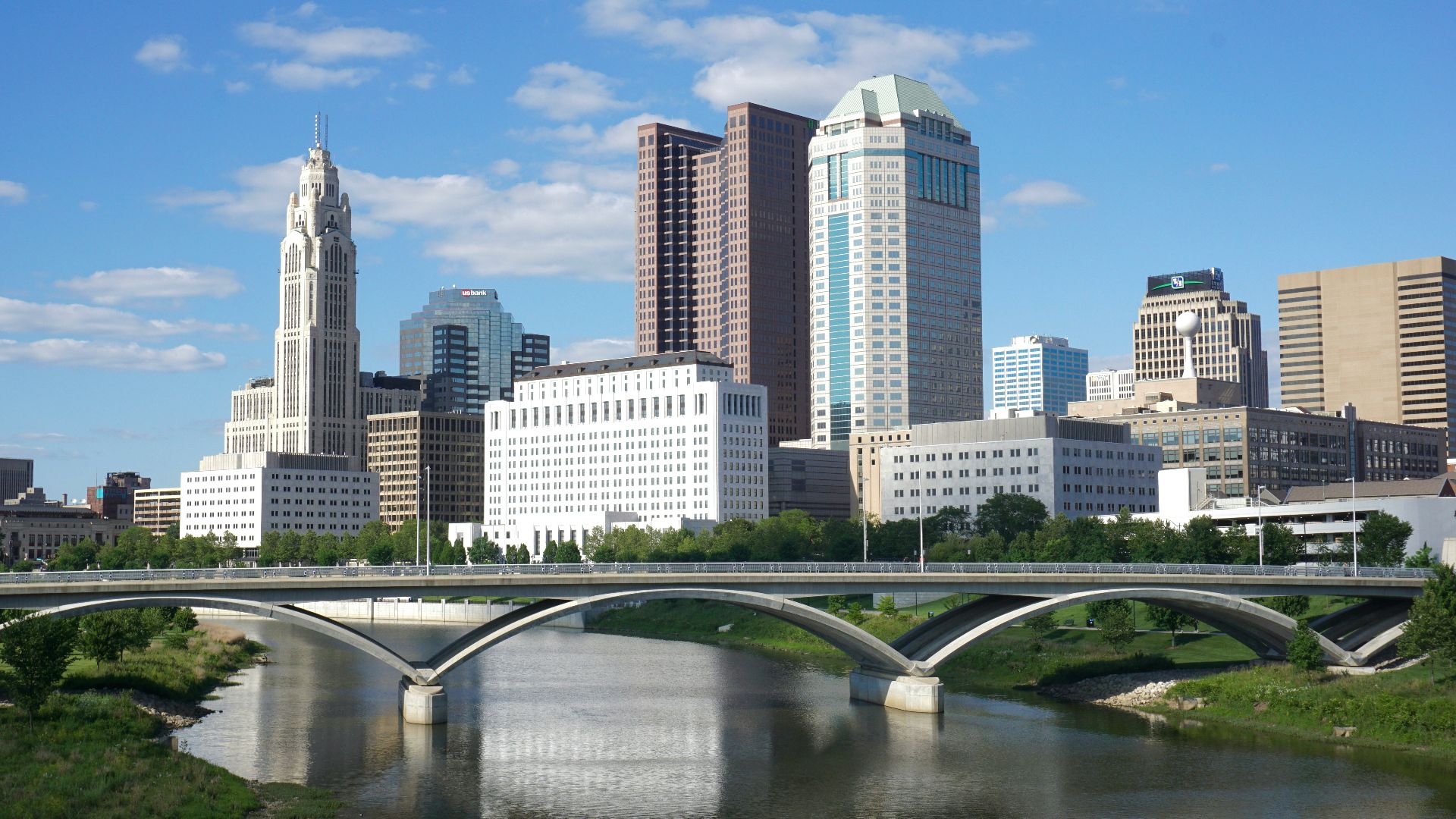 a bridge over a river with a city in the background