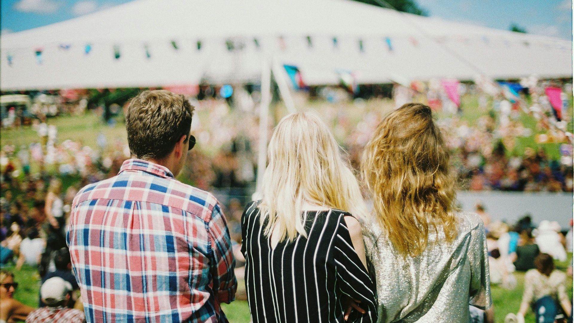 three person's standing front of field