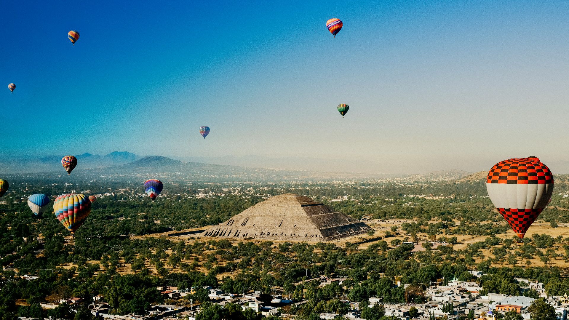a group of hot air balloons flying over a city