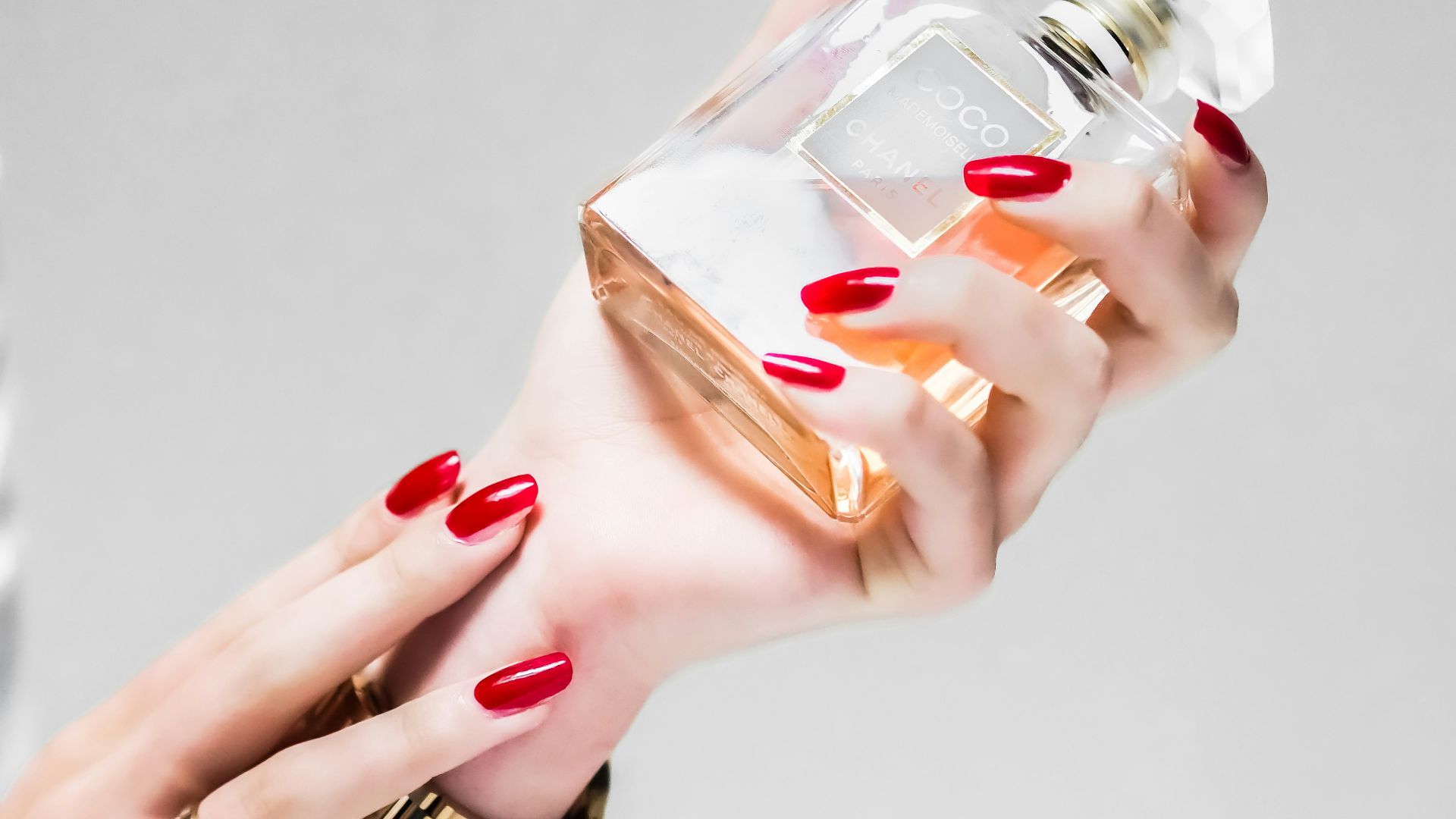 person holding clear glass bottle