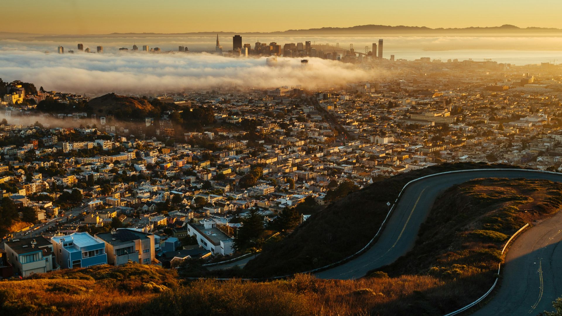 a view of a city from a hill above the clouds